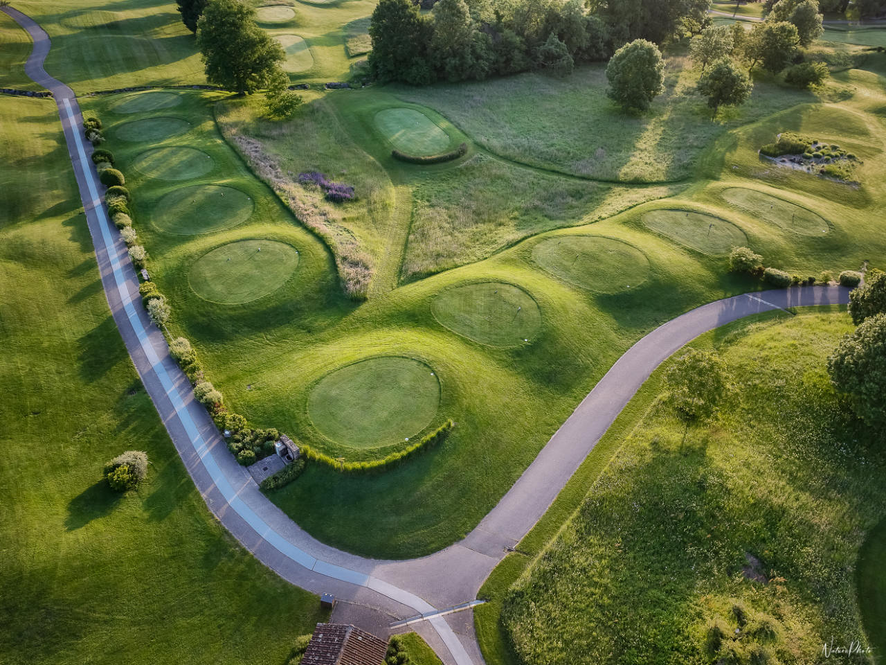 Vue aérienne d’un parcours de golf, de ses greens et de l’allée qui le traverse