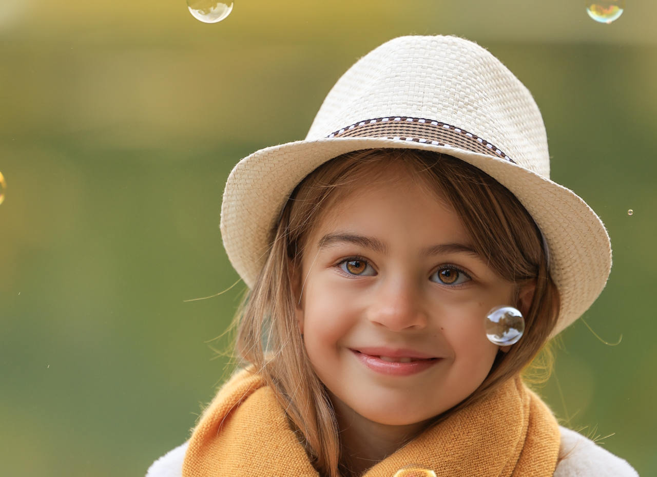 Portrait souriant d’une fillette au chapeau de paille et à l’écharpe jaune