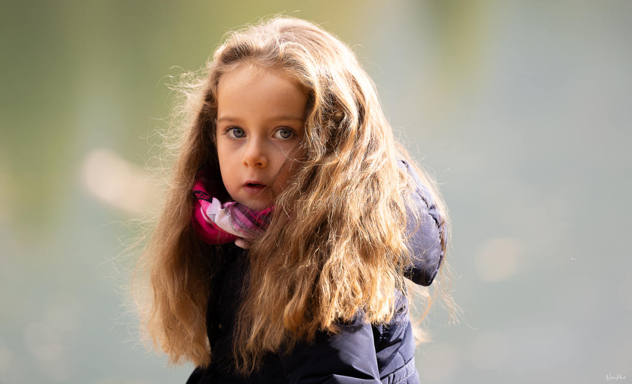 Portrait d’une fillette aux longs cheveux bouclés, lumière douce d’automne