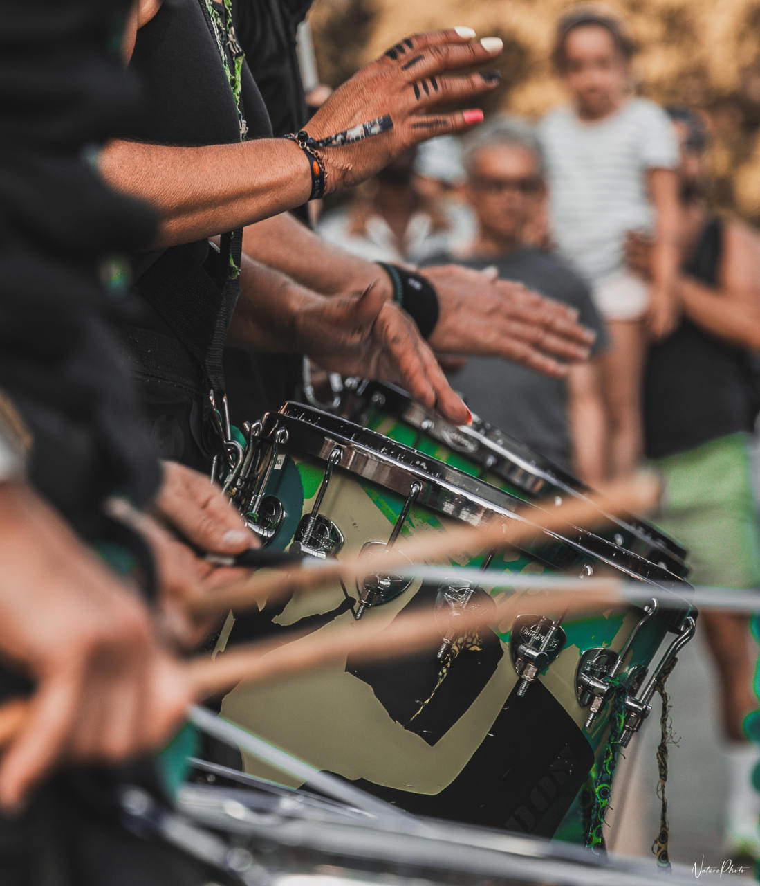 Mains de percussionnistes qui frappent leurs tambours devant le public